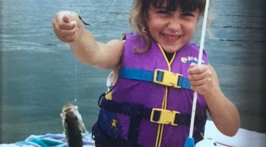 girl smiling holding a fish