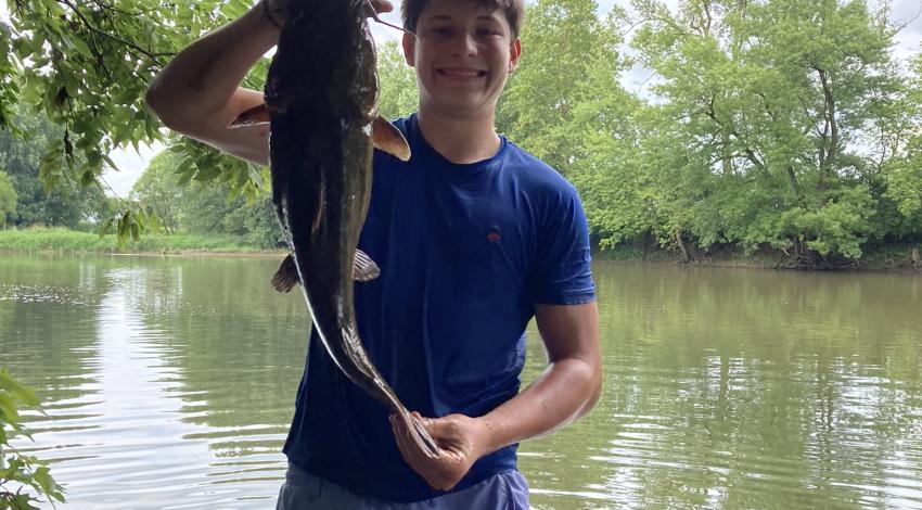 boy smiling holding a fish
