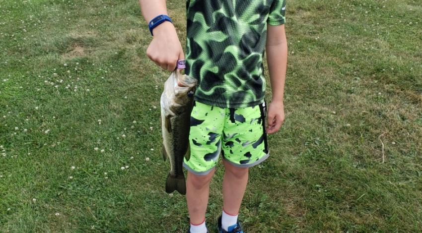 boy smiling holding a fish