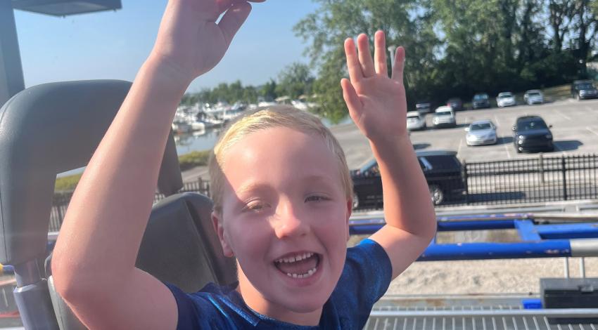 boy with hands in the air on roller coaster