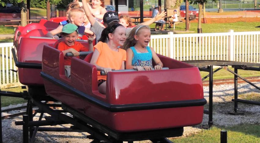 children in red roller coaster car
