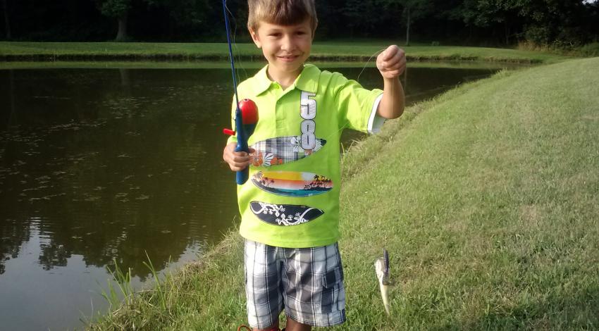 boy smiling holding a fish