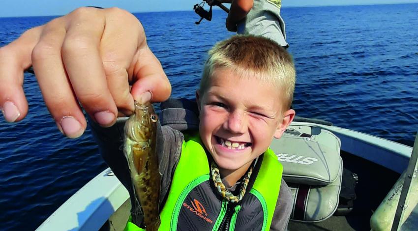boy smiling holding a minnow 