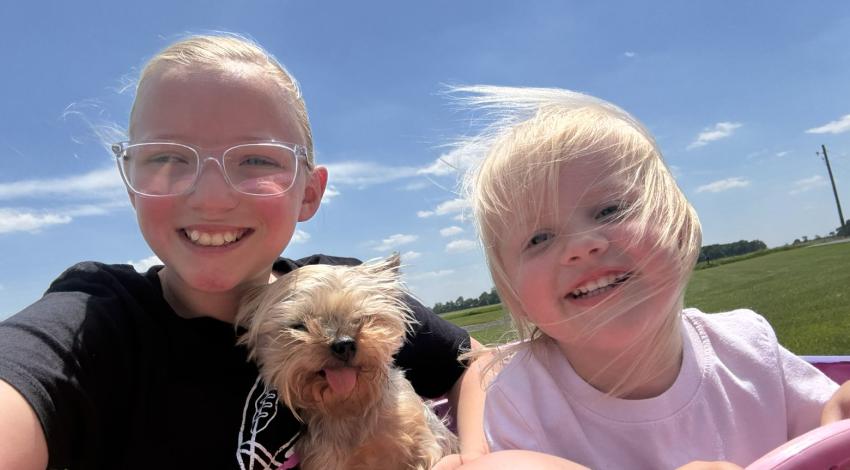 two little girls with a small dog