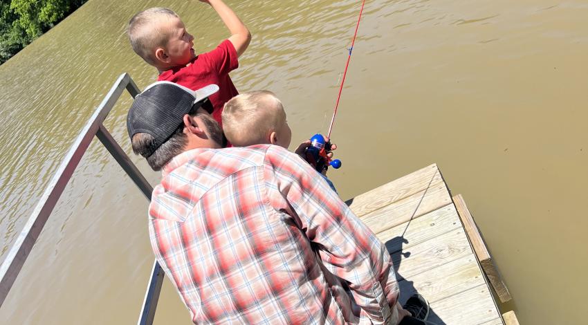 two little boys fishing with their dad