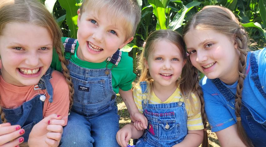 four smiling kids outside