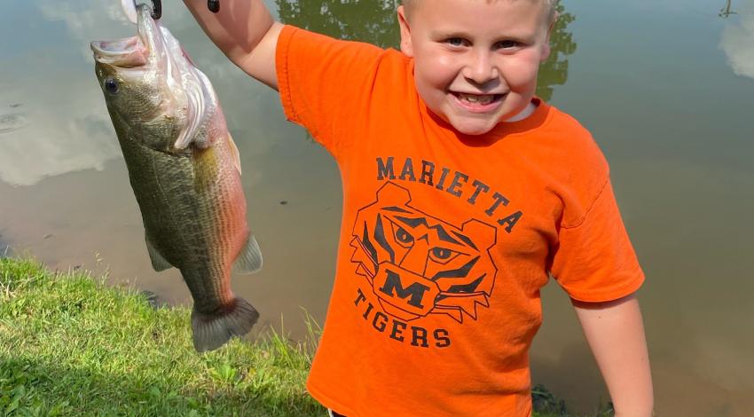 Boy smiling holding fish