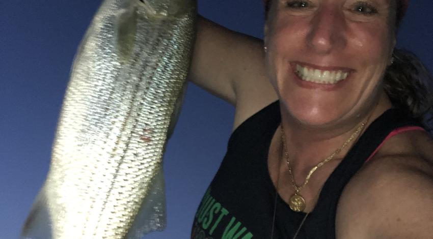 Woman smiling holding up a fish