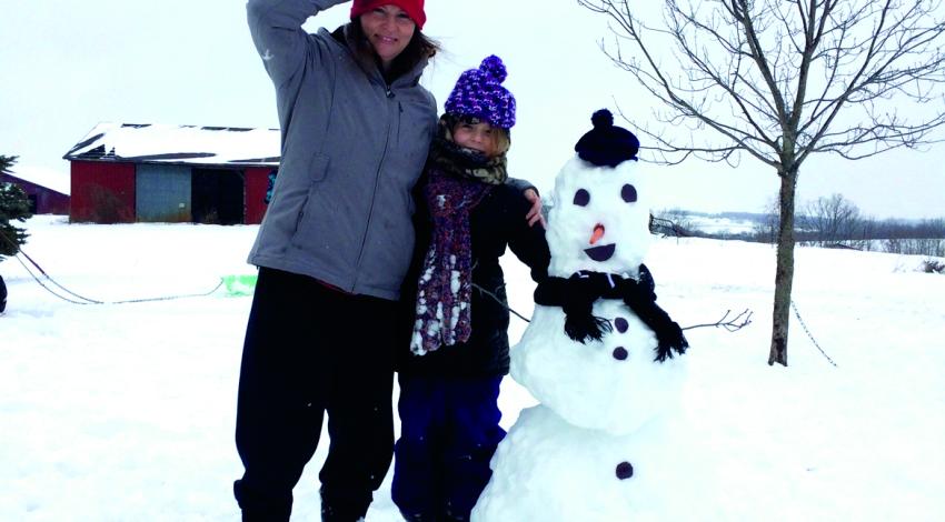 woman and girl next to a snowman