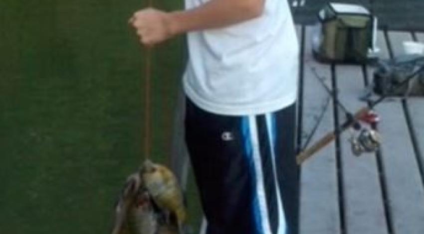boy smiling while holding a line fish