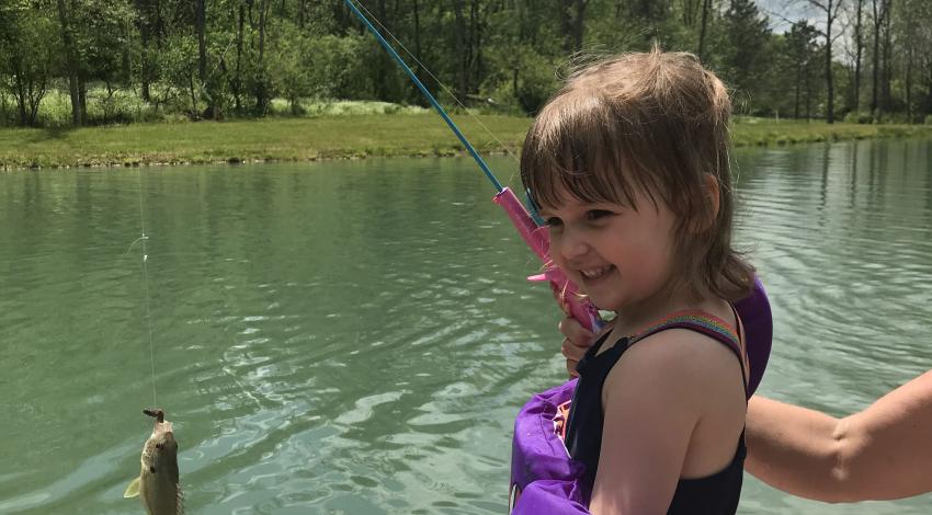 Smiling girl holding a fish