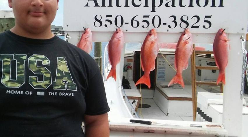 Boy standing next to his caught fish