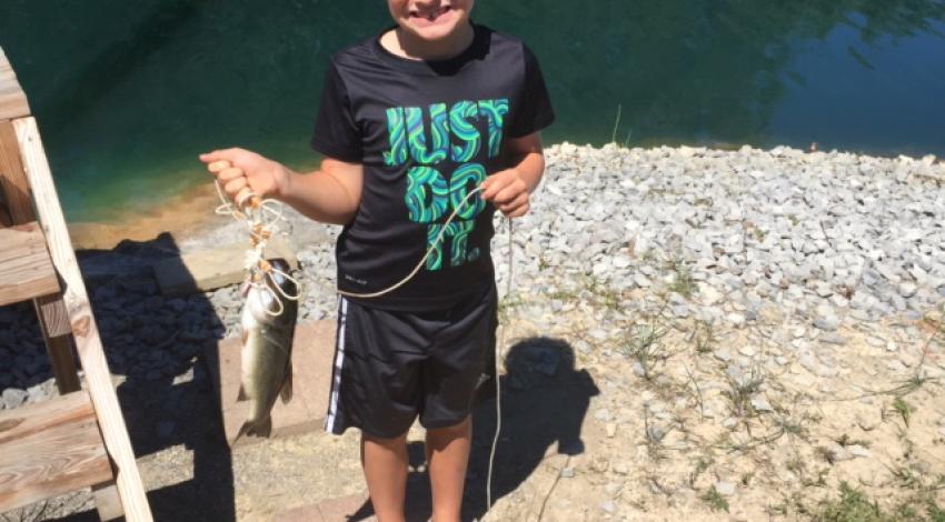 boy smiling holding a fish