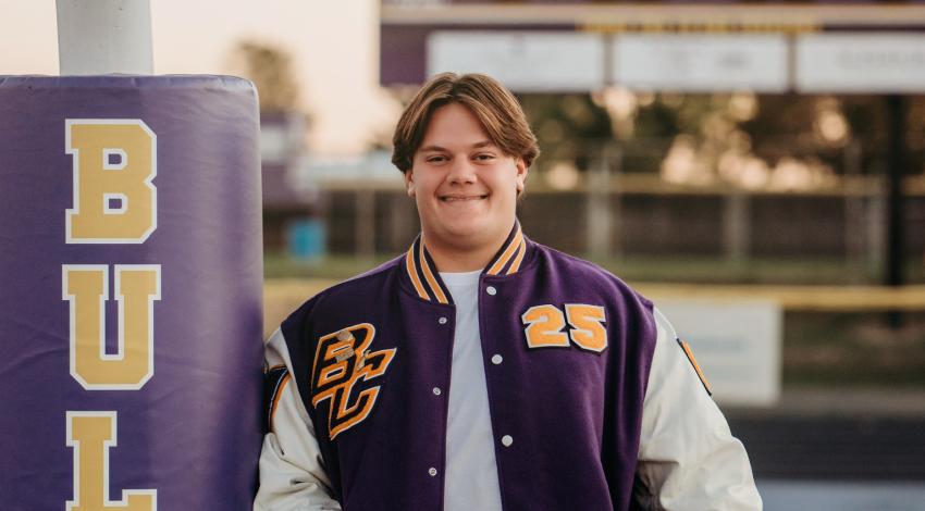 young man in letter jacket holding a football