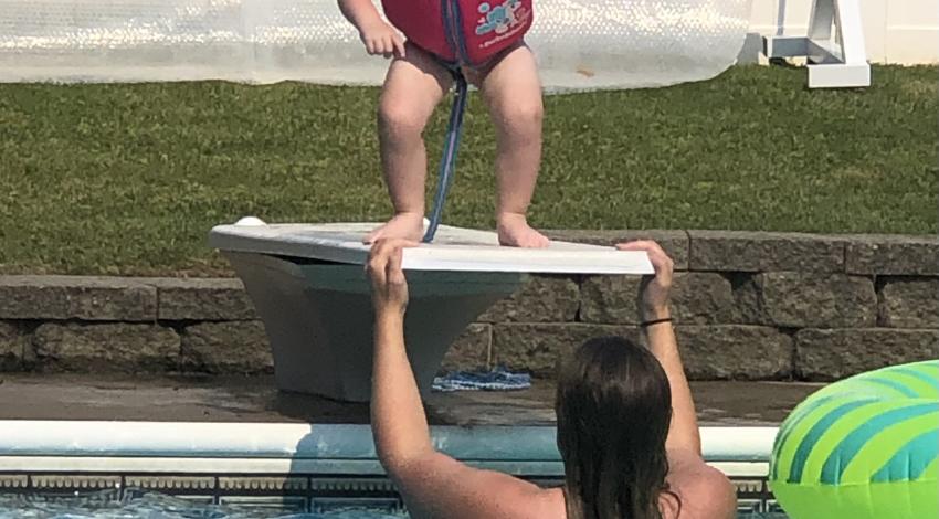 little girl in life jacket on diving board