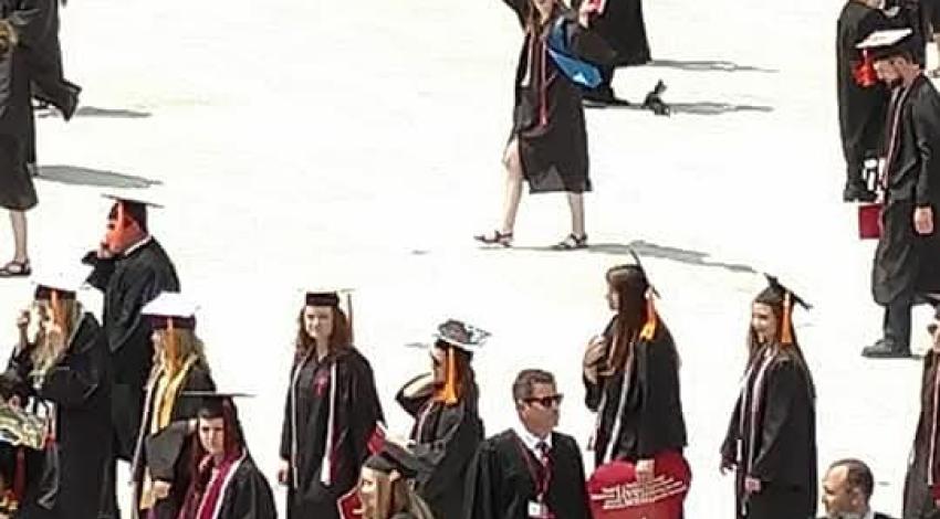 Young woman in crowd of graduates in black gowns