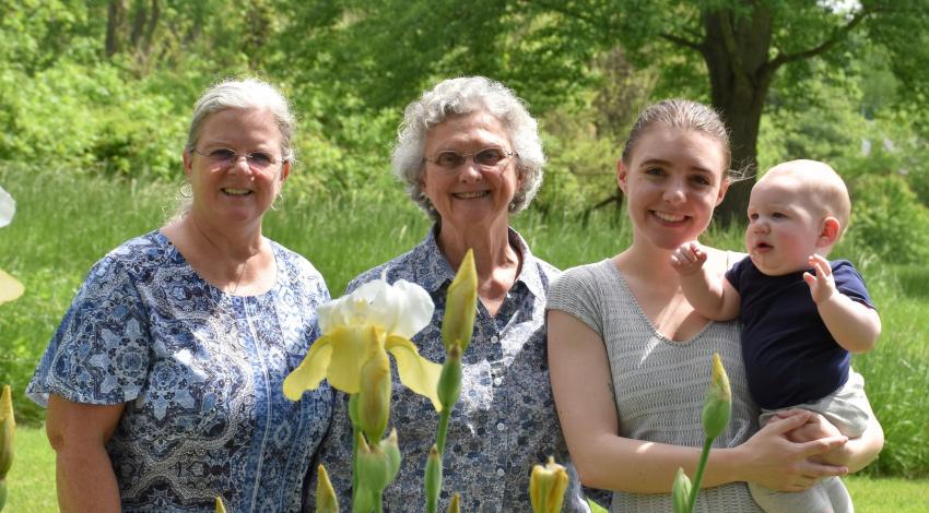 three women and a baby in a garden