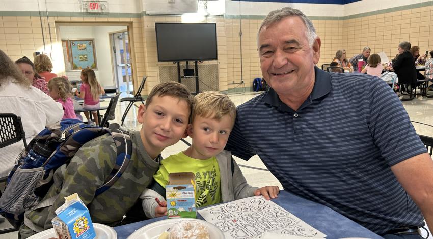 man at lunch table with two small boys