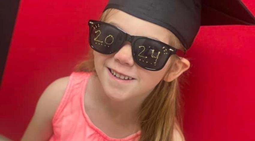 little girl in black graduation cap and sunglasses