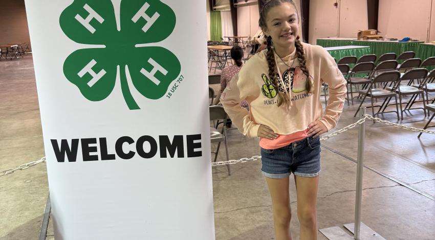 girl by 4-H sign