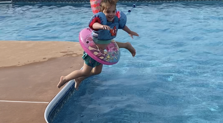 two small children jump into pool