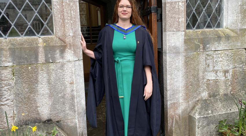 young woman in black graduation gown