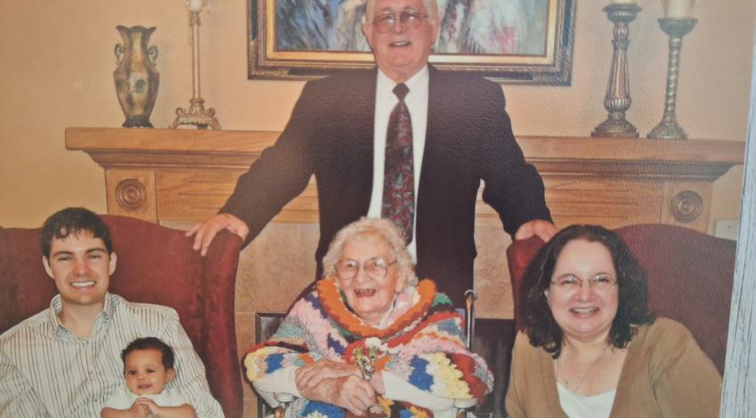 several generations pose in front of fireplace