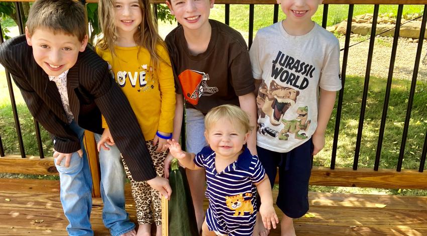 children on a deck with large zucchini