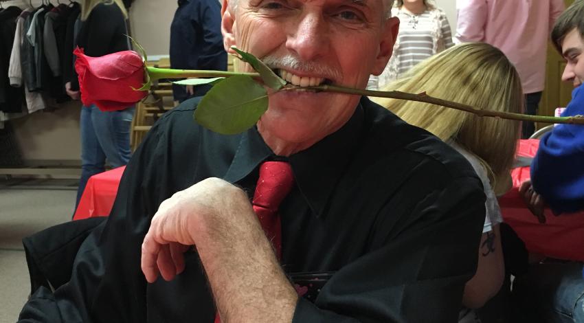 man with rose in his teeth