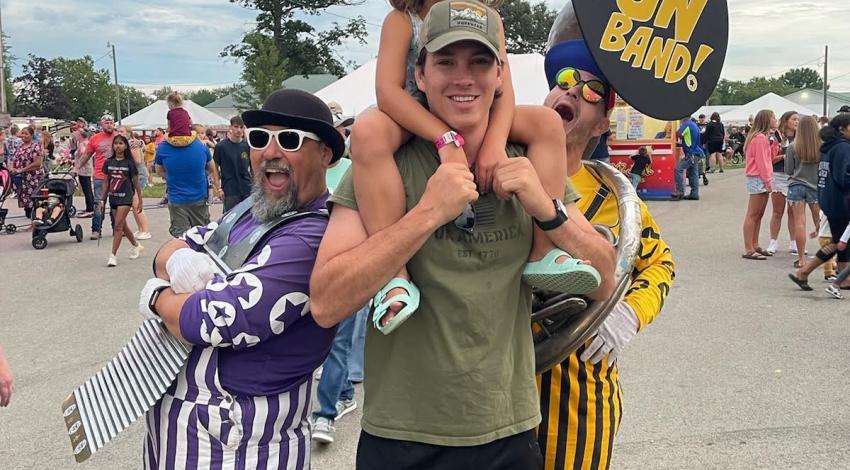 little girl on man's shoulders, with clowns