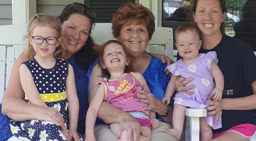 three women and three little girls on a porch