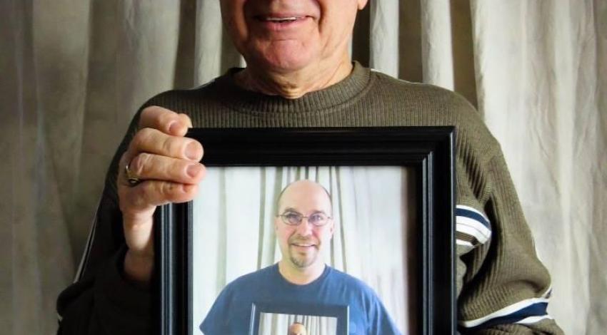 man holding photo of man holding photo, etc.