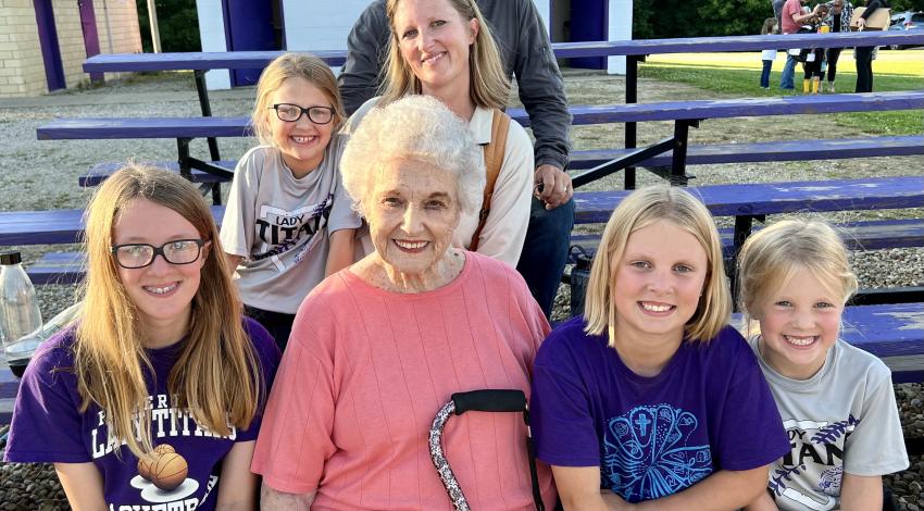 several generations of a family seated on bleachers