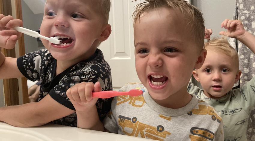 three little boys brushing their teeth