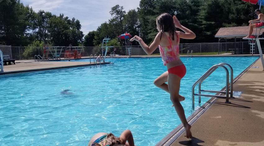 girl jumps in pool