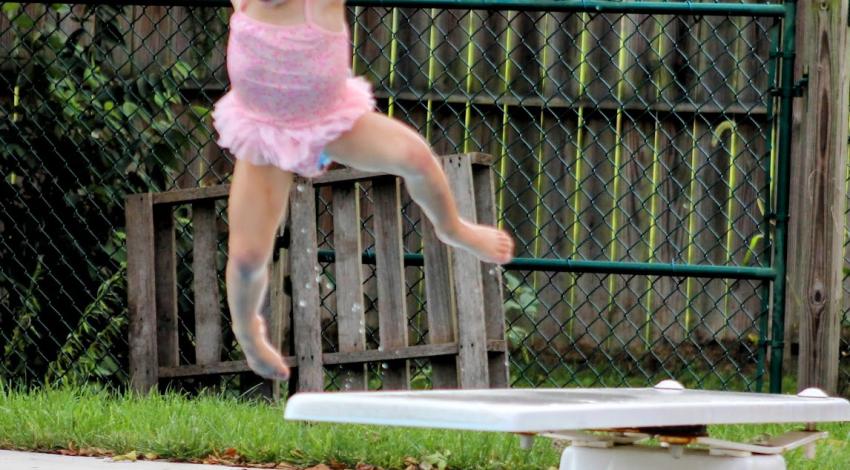 little girl jumps off diving board