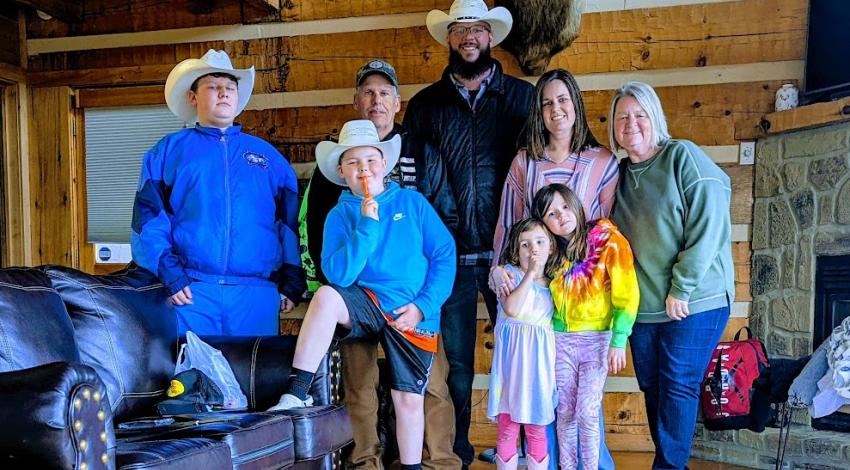 family in cabin beneath deer head on wall