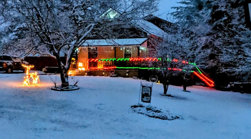 house with Christmas lights in snow