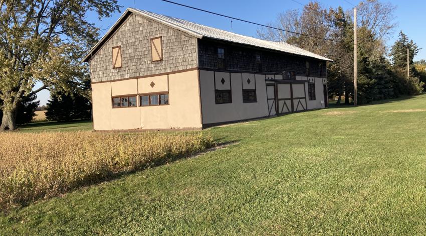 Tan stucco barn with dark brown trim.
