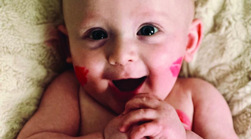 baby covered in lipstick kisses