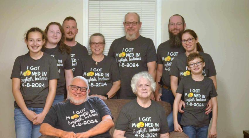 family group seated, in matching shirts