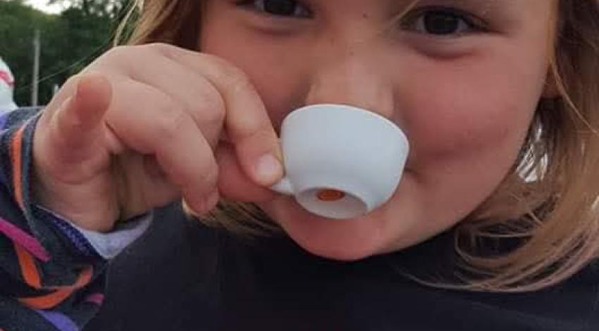 little girl drinking from tiny teacup