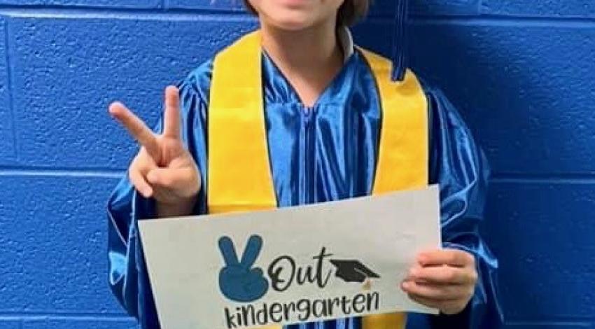 little boy in blue graduation cap and gown