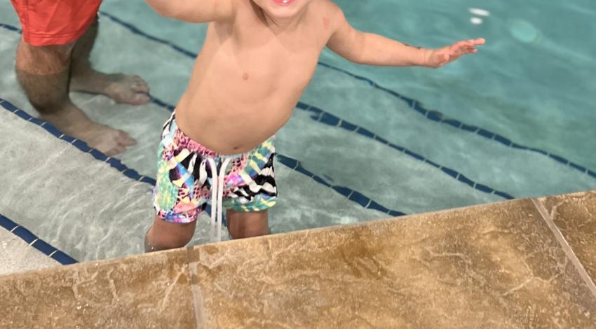 little boy on pool stairs