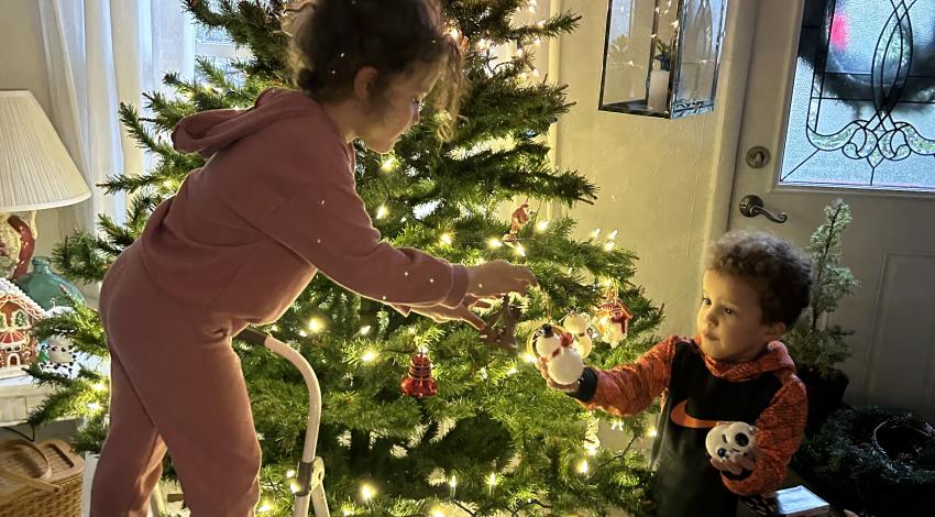 girl and boy decorating Christmas tree