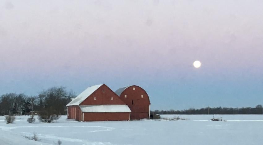 Big red barn surrounded by snowy fields