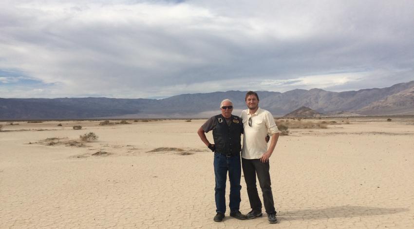 two men standing in desert