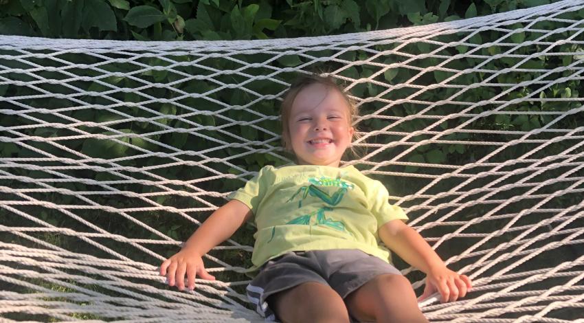 smiling girl reclines on hammock
