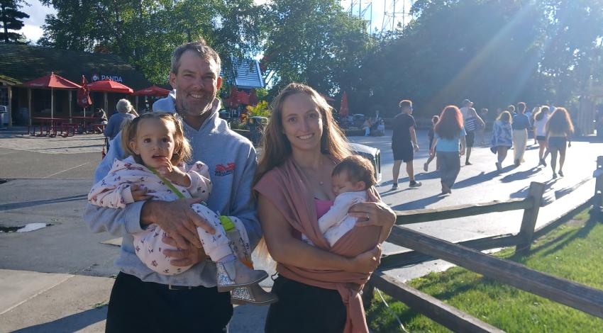 family standing in front of roller coaster