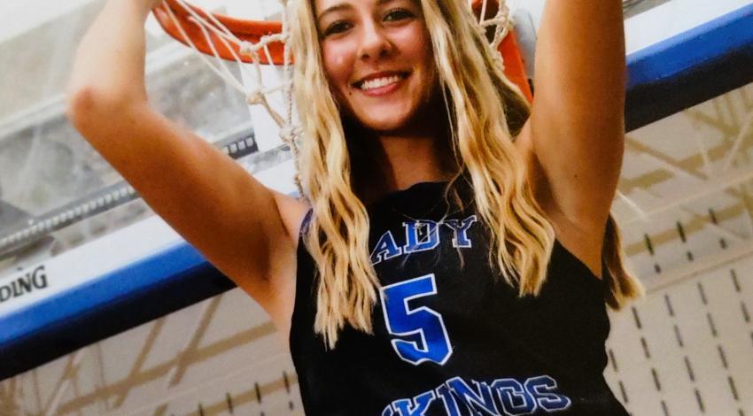 teenage girl holding basketball hoop